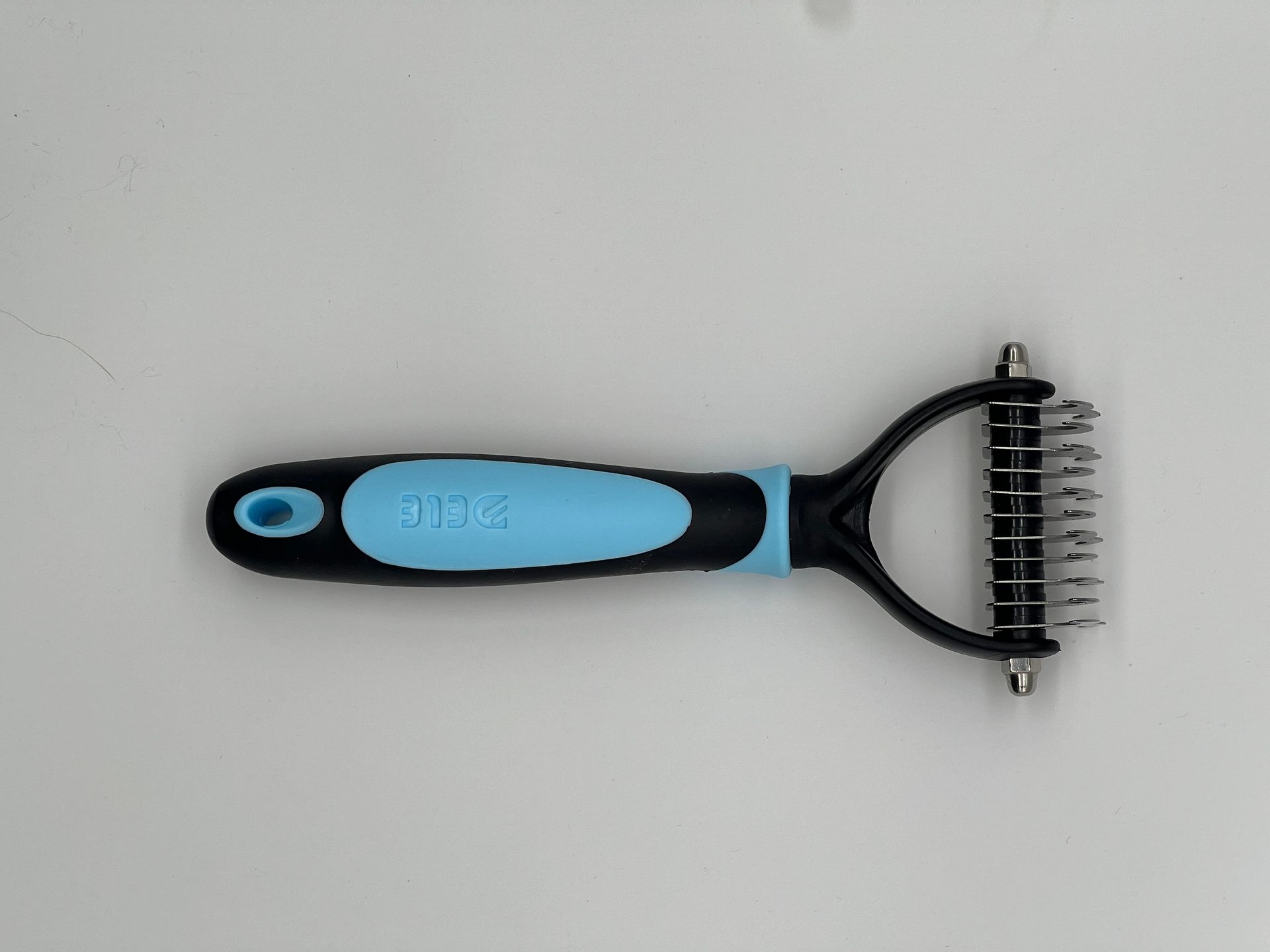 A black and blue comb with a blue handle on a white surface.