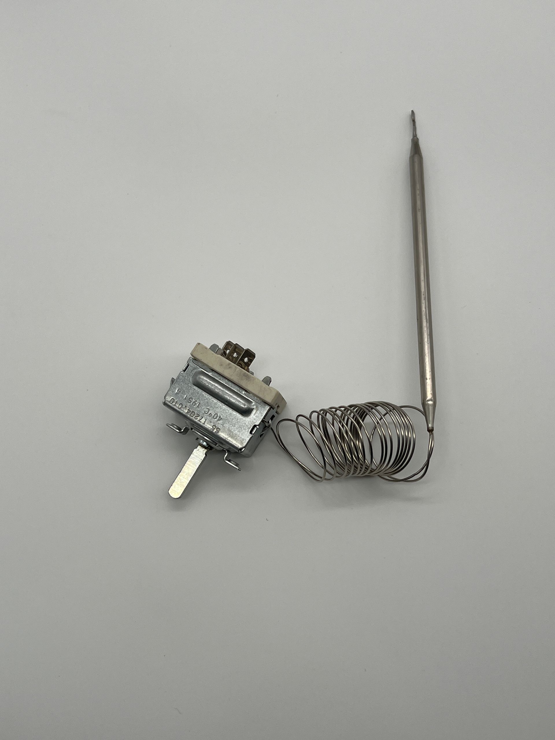 A close up of a thermostat on a white surface.