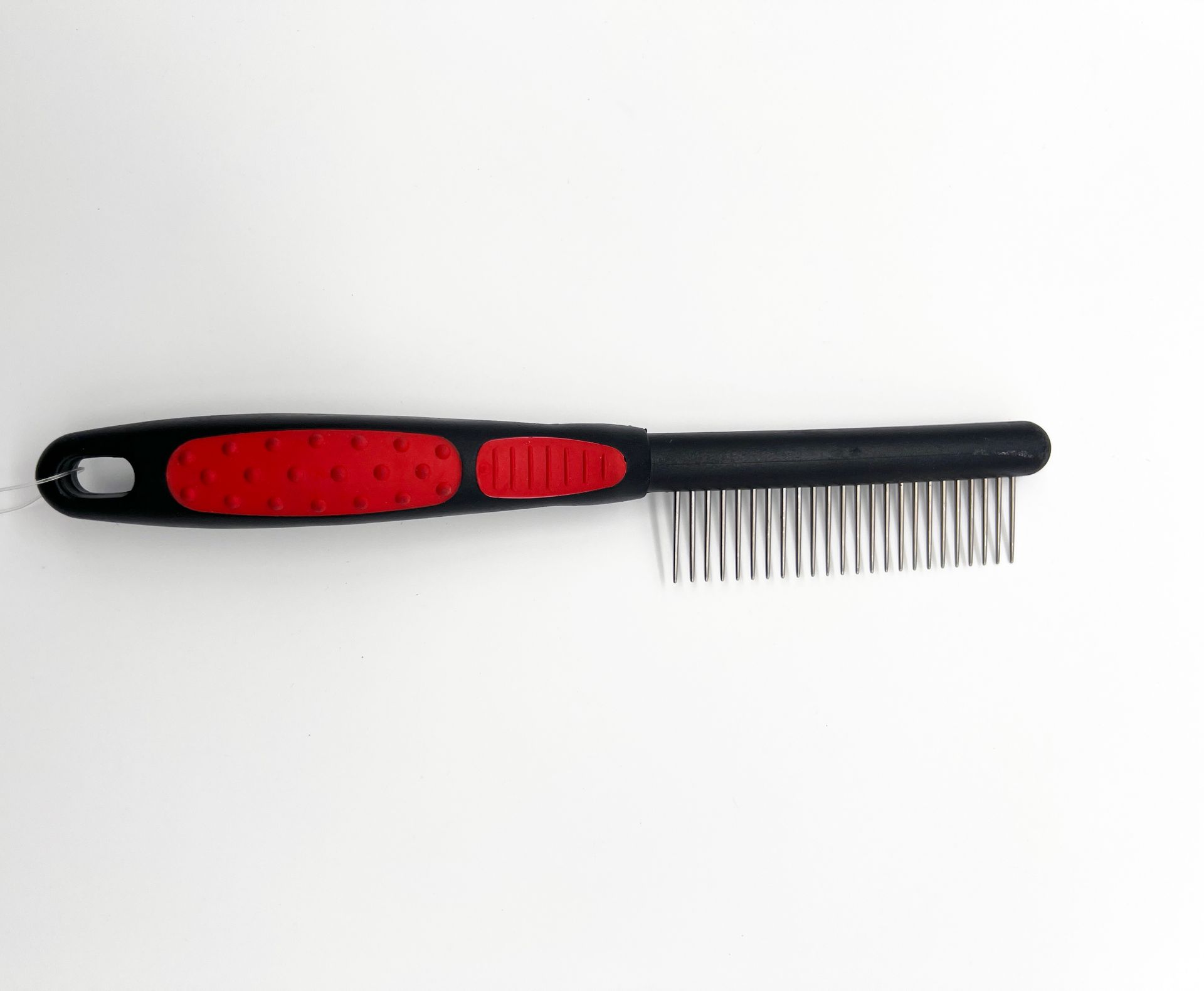 A black comb with a red handle on a white surface