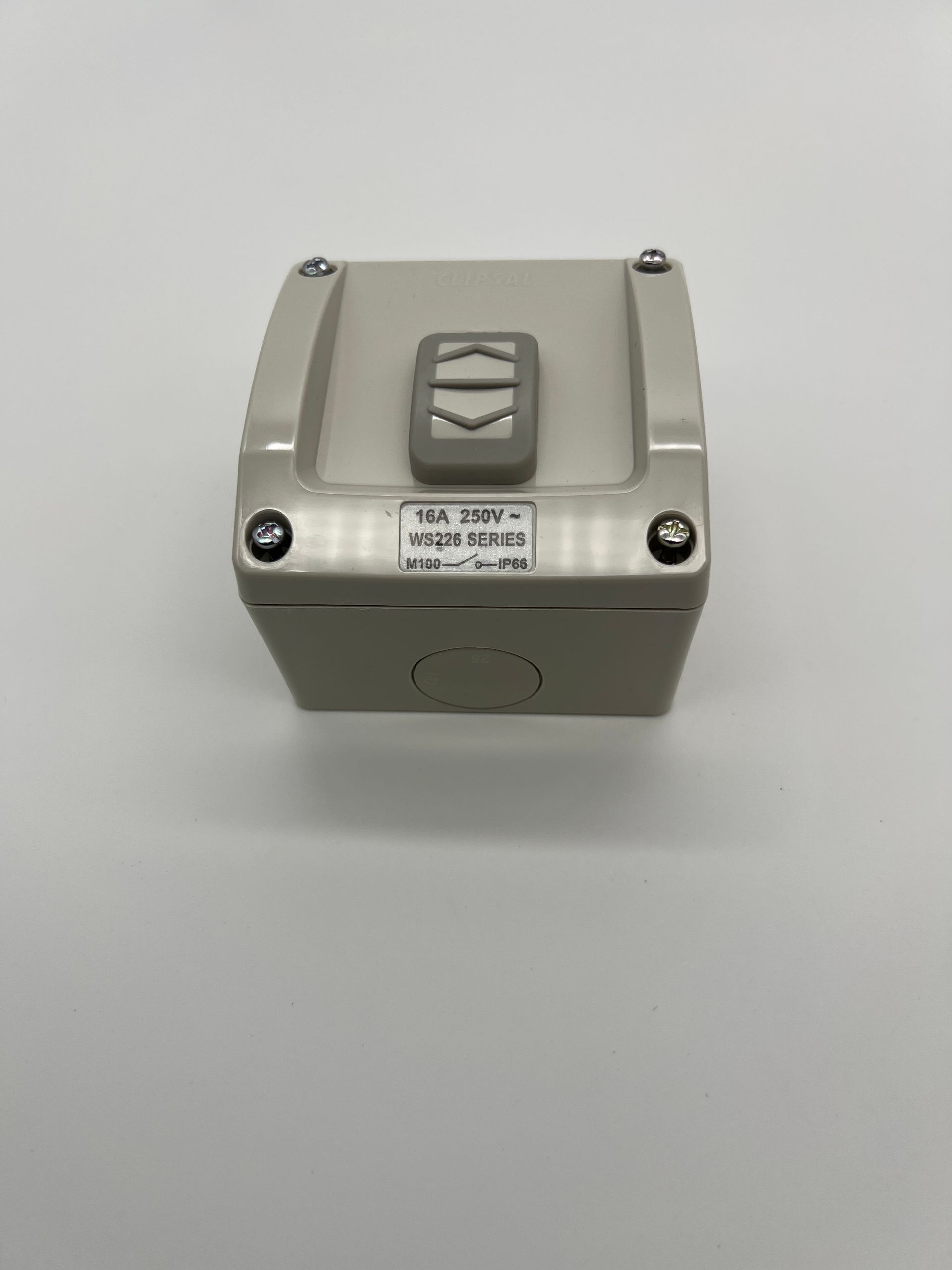 A white box with a button on it is sitting on a white surface.