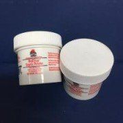 Two jars of toothpaste are sitting next to each other on a blue surface.