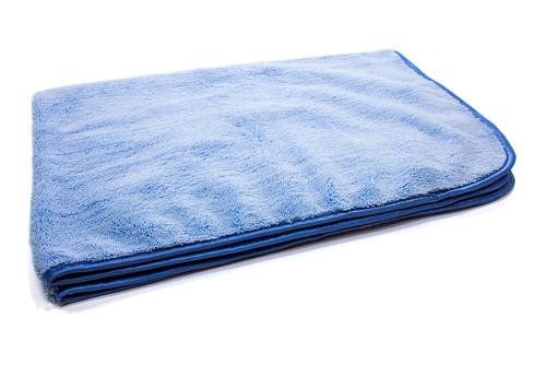 A blue towel is sitting on a white surface.