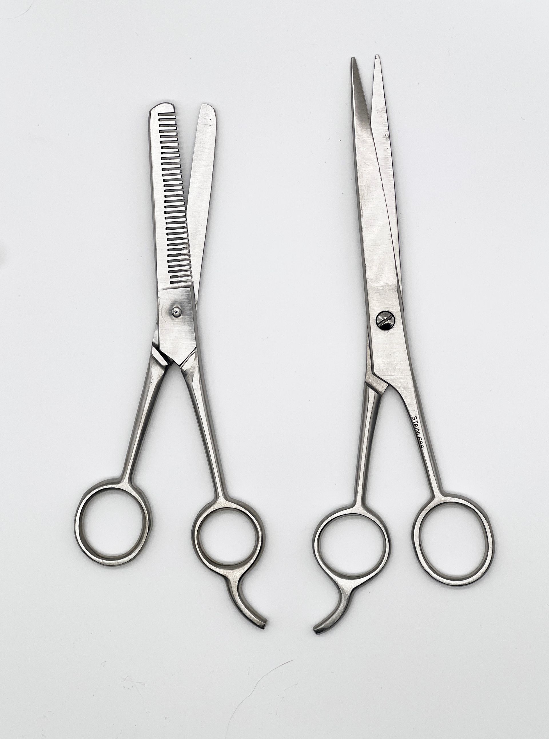 A pair of scissors with one that says thinning on it