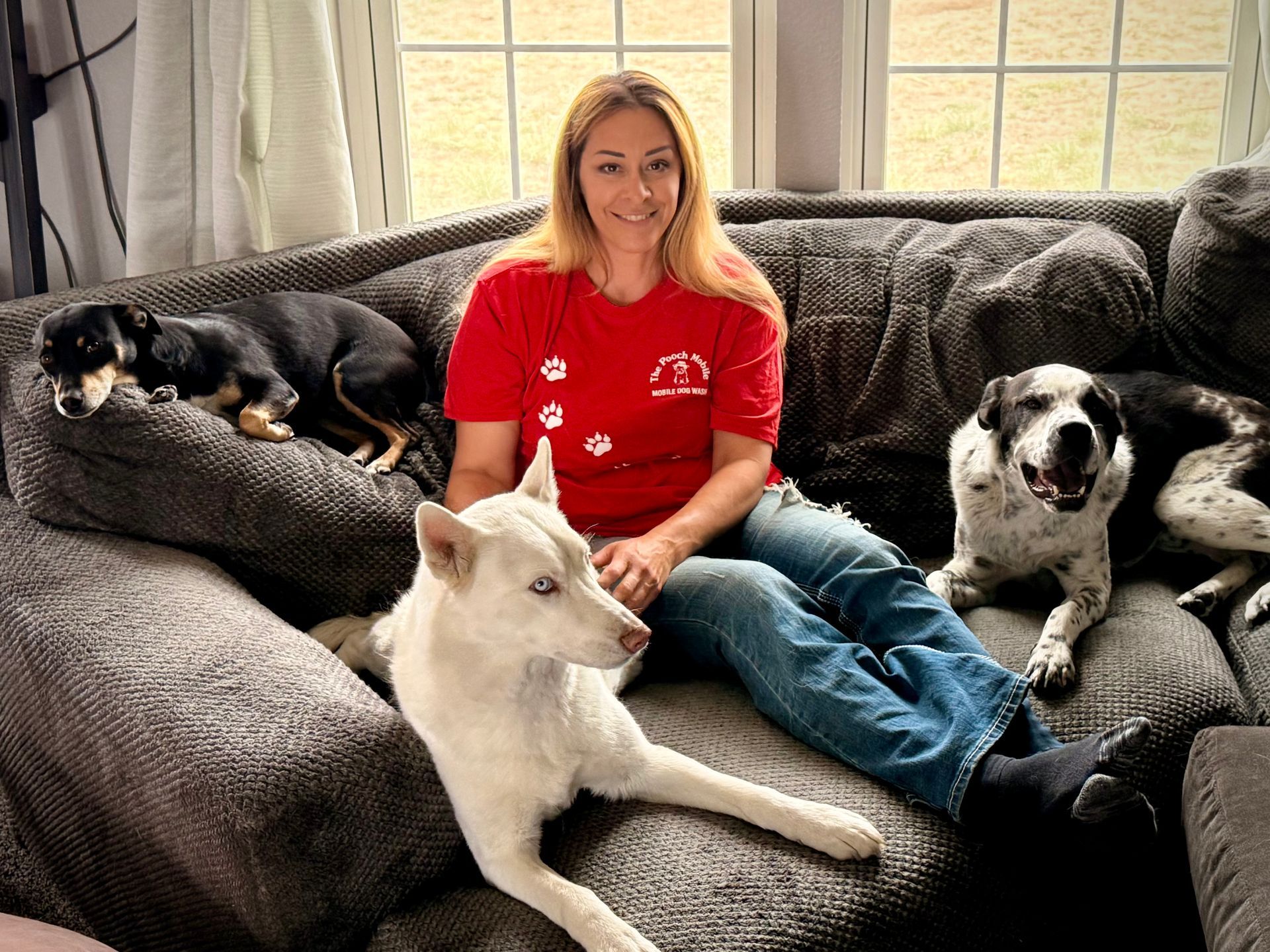 A woman is standing next to a white dog in a trailer