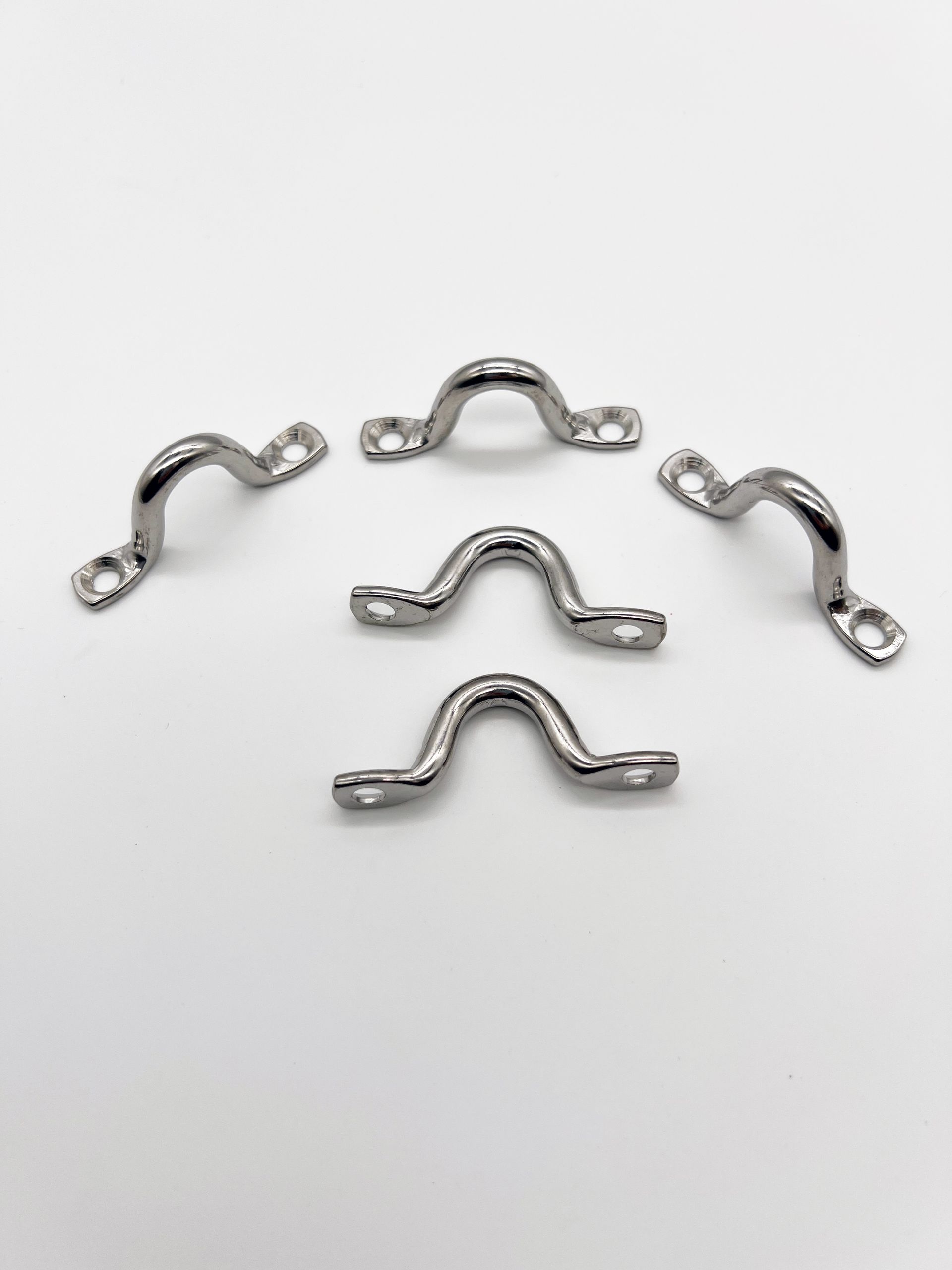 A group of stainless steel handles on a white surface