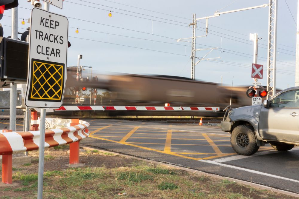 A Truck Is Driving Through A Railroad Crossing With A Sign That Says Keep Tracks Clear — Australian Specialised Machinery Glass In Blackwater, QLD