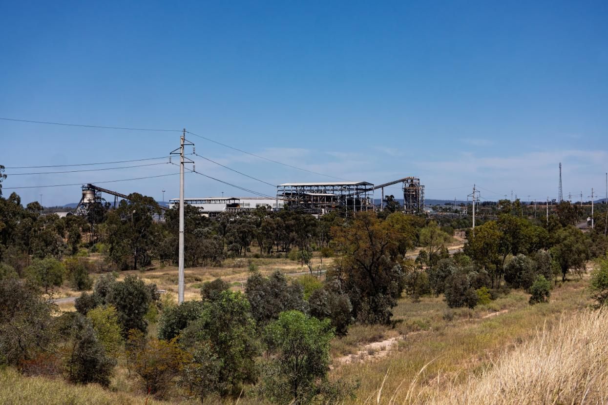 There Is A Factory In The Background And A Lot Of Trees In The Foreground — Australian Specialised Machinery Glass In Moranbah, QLD