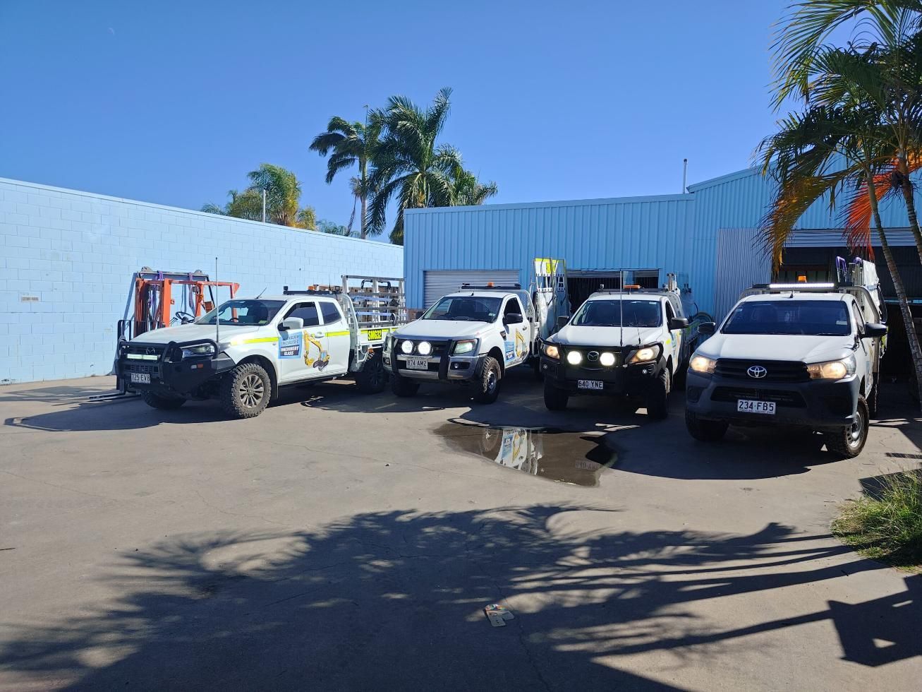 A Row Of Trucks Are Parked In Front Of A Building — Australian Specialised Machinery Glass In Emerald, QLD
