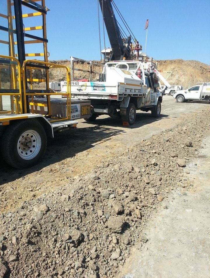 A Truck With A Crane On The Back Is Parked On A Dirt Road — Australian Specialised Machinery Glass In Mackay, QLD