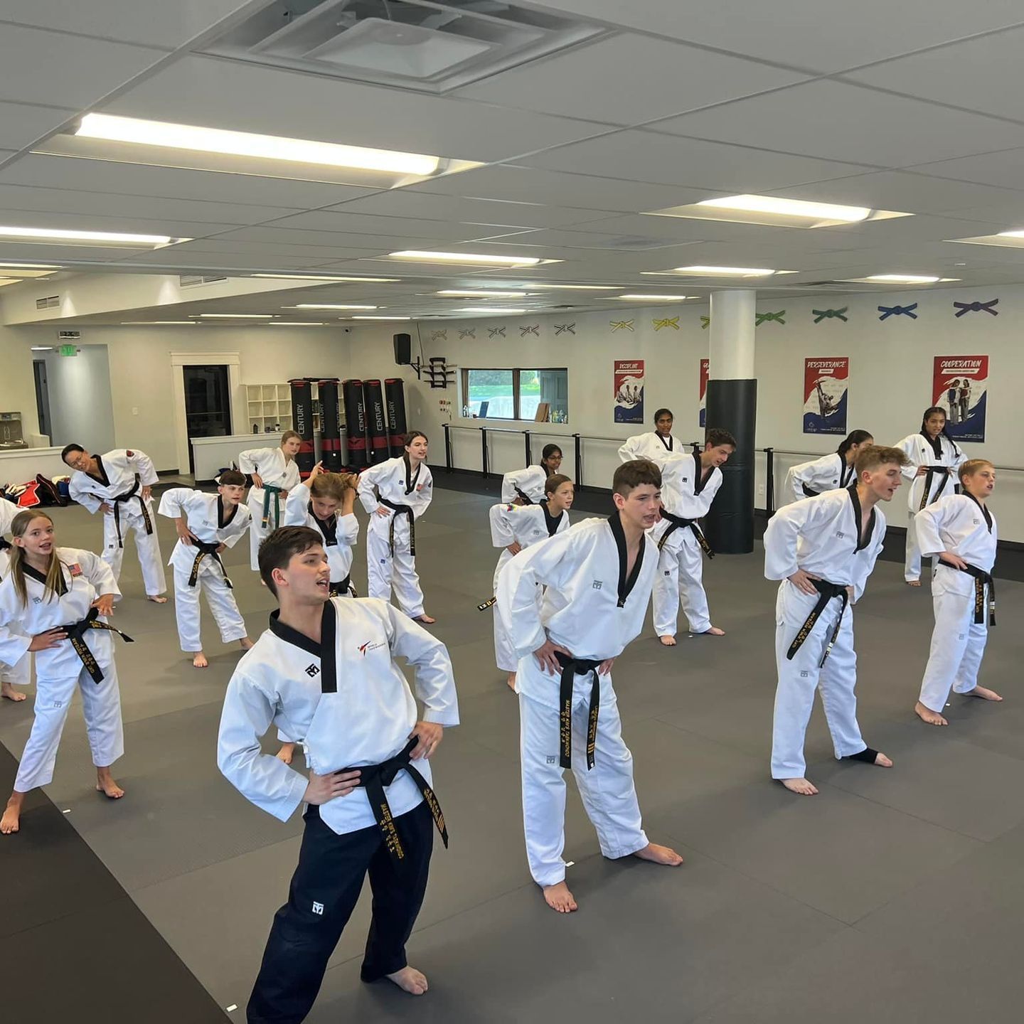 A group of men are practicing karate in a gym.