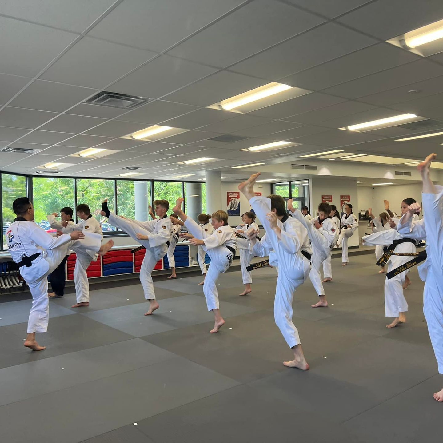 A group of men are practicing karate in a gym.