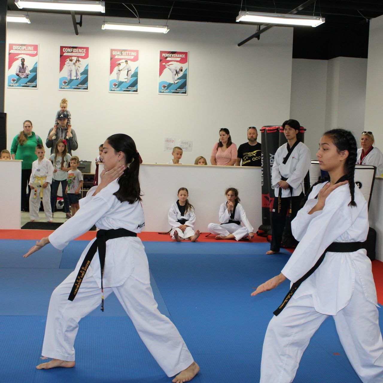 A group of men are practicing karate in a gym.