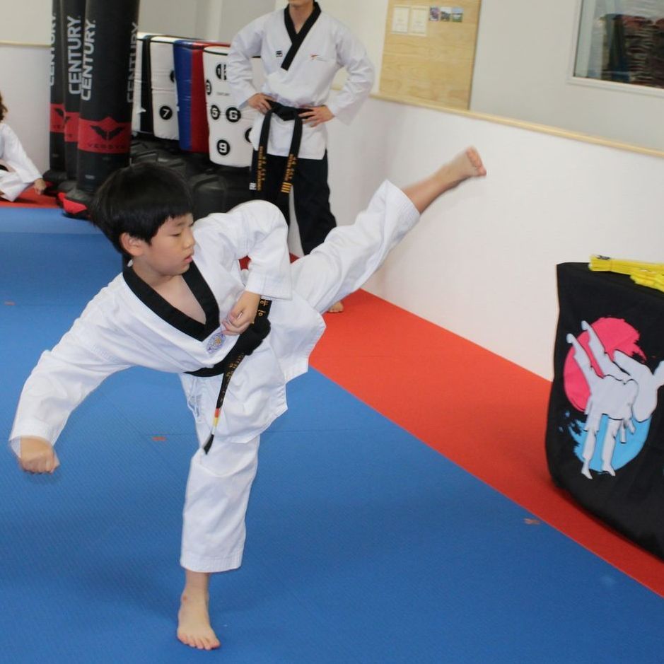 A group of men are practicing karate in a gym.