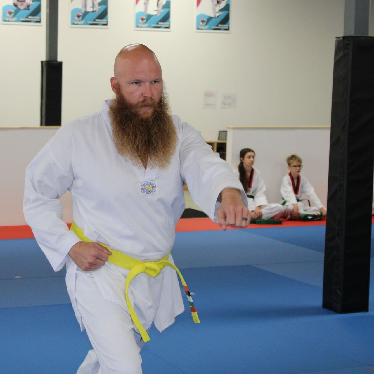 A group of men are practicing karate in a gym.