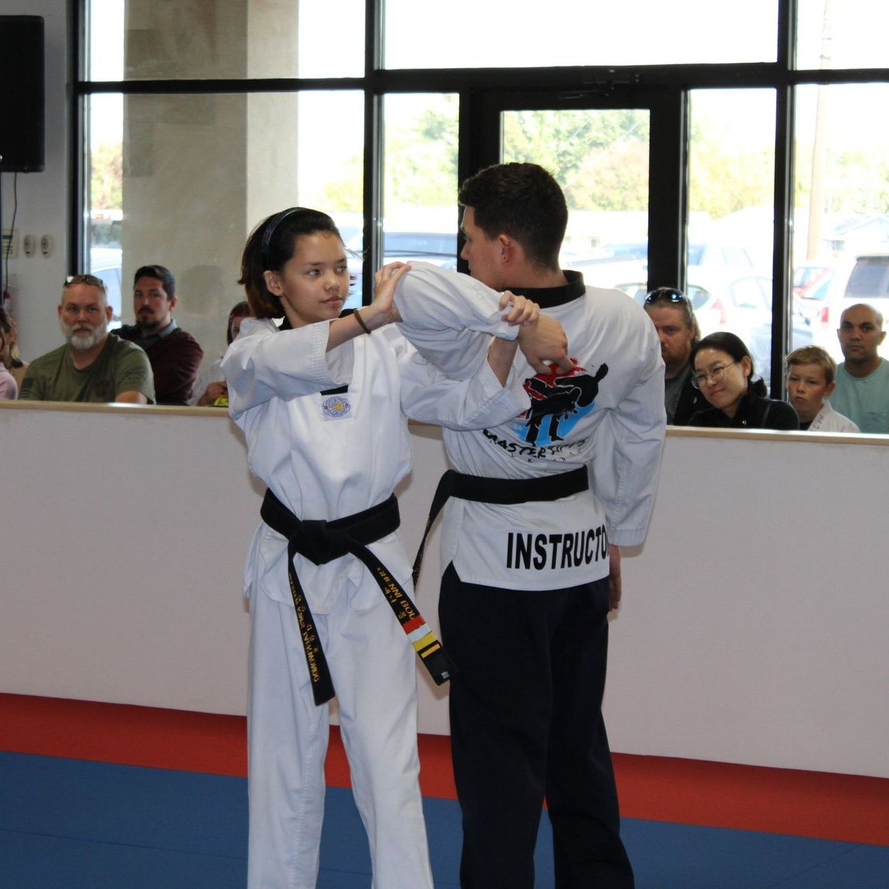 Two young men are practicing karate on a mat