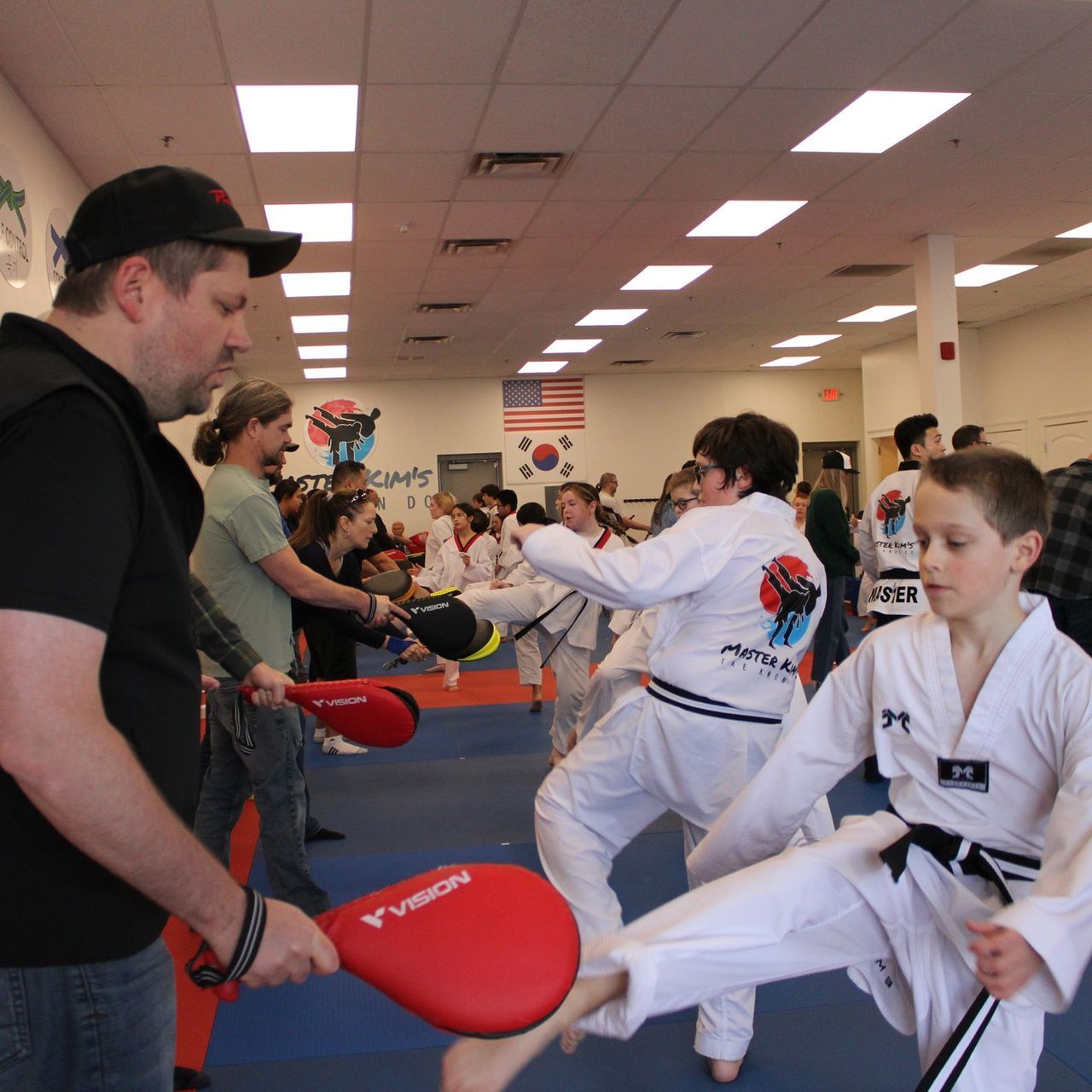 A boy and a girl are practicing taekwondo together.