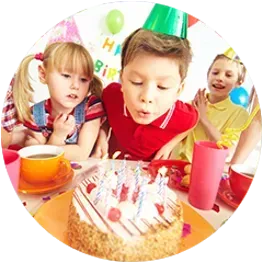 A group of children are blowing out candles on a birthday cake.