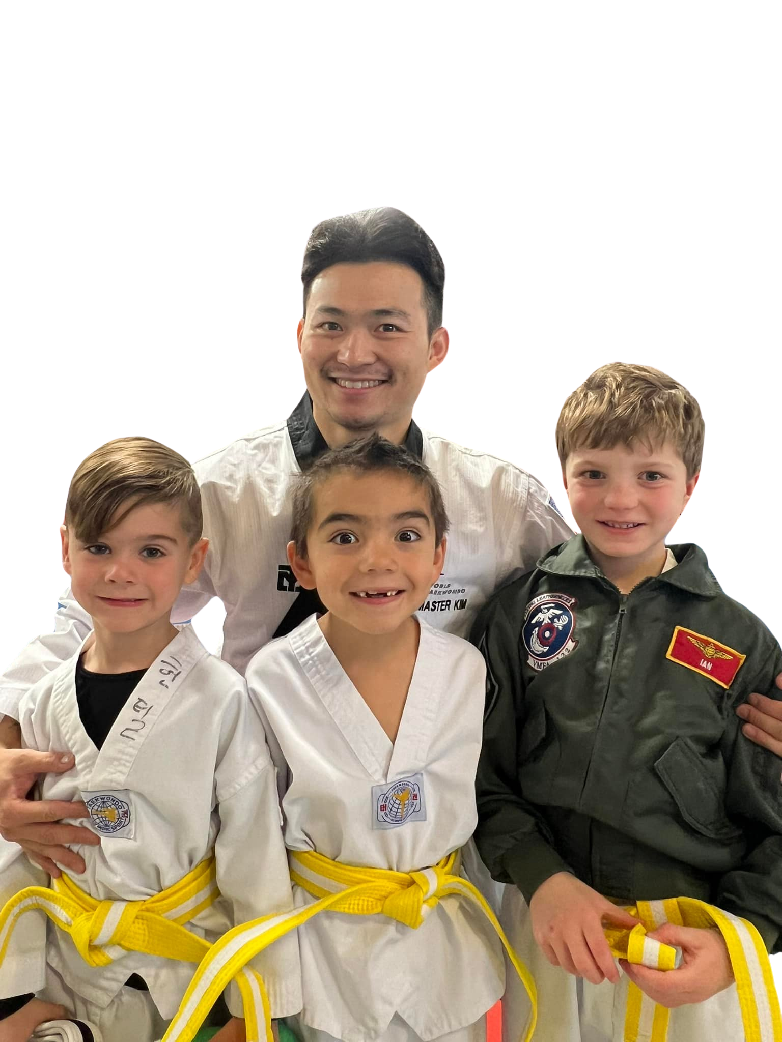 A boy and two girls are wearing karate uniforms and pointing at the camera