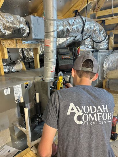 Open attic with HVAC ductwork and labeled utility panels in a wood-framed space