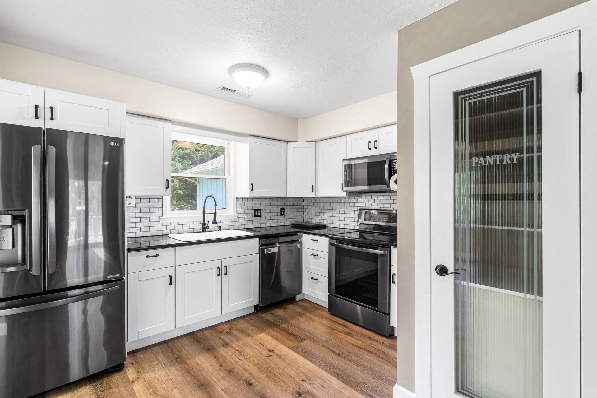 Boxes stacked in a room with a white couch, indicating a move; bright sunlight.