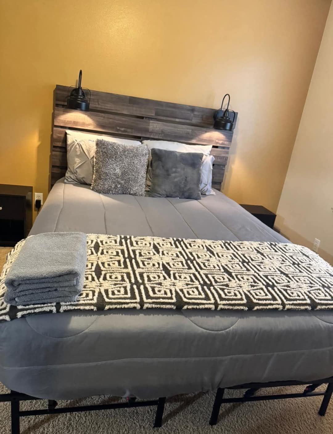 Yazzi's Cleaning - A bedroom with a bed , nightstands , and a wooden headboard.