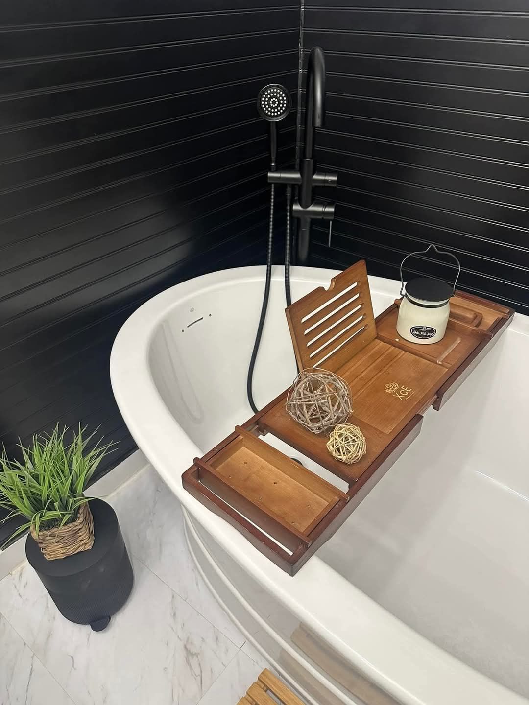 A bathtub with a wooden tray on top of it.