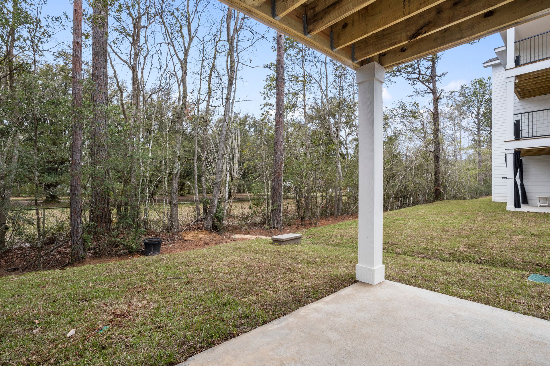 Photo of the outside area behind the property, showing a lightly wooded area