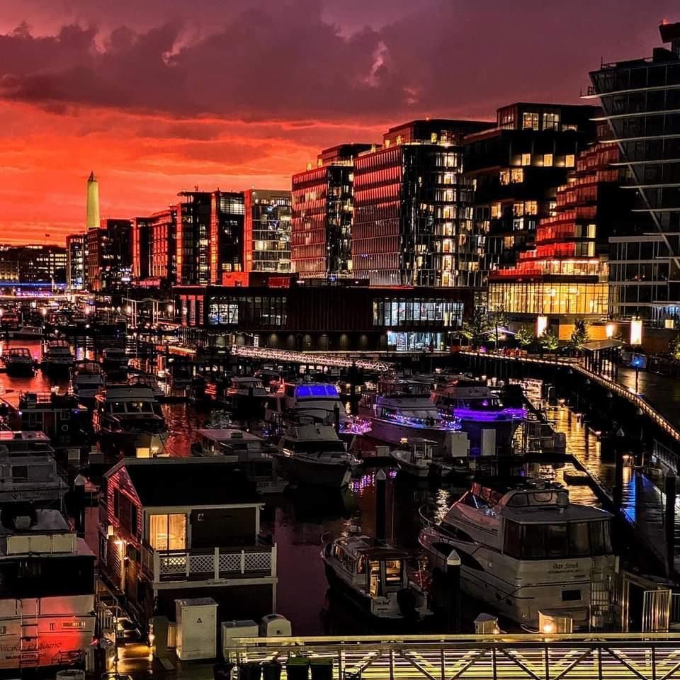 Stunning red sunset over the buildings and the boats at The Wharf in SW DC with Washington monument in the background