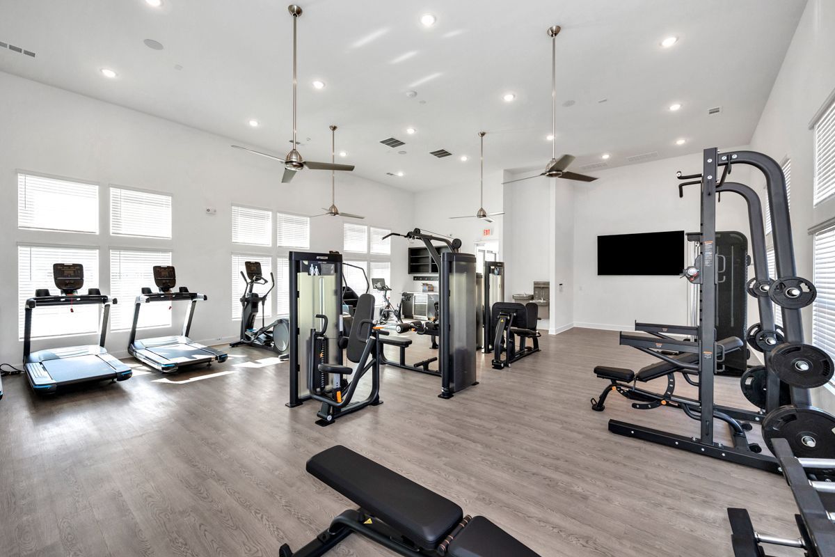 Well-equipped fitness center with various exercise machines and natural light.