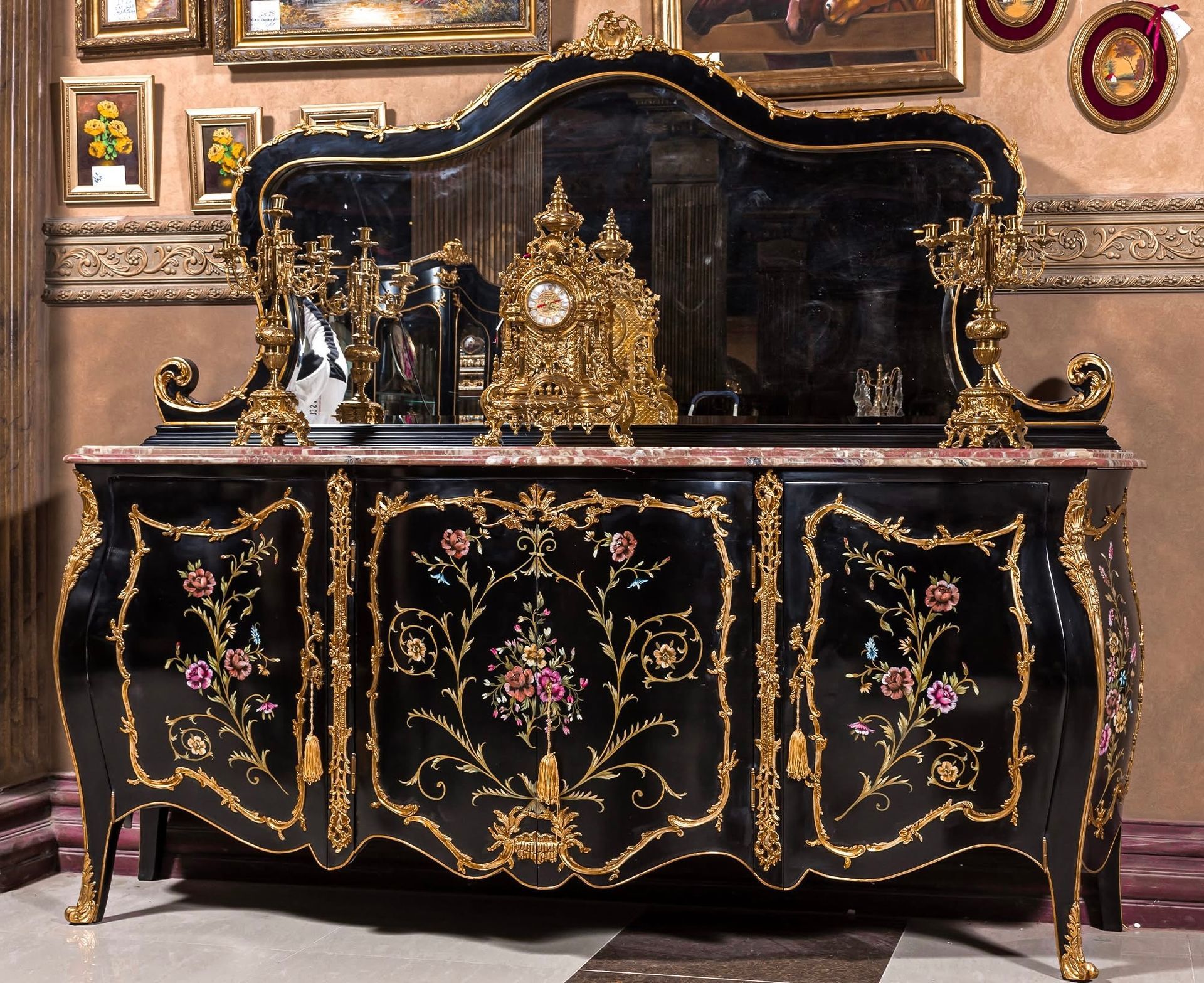 A black and gold dresser with a clock on top of it