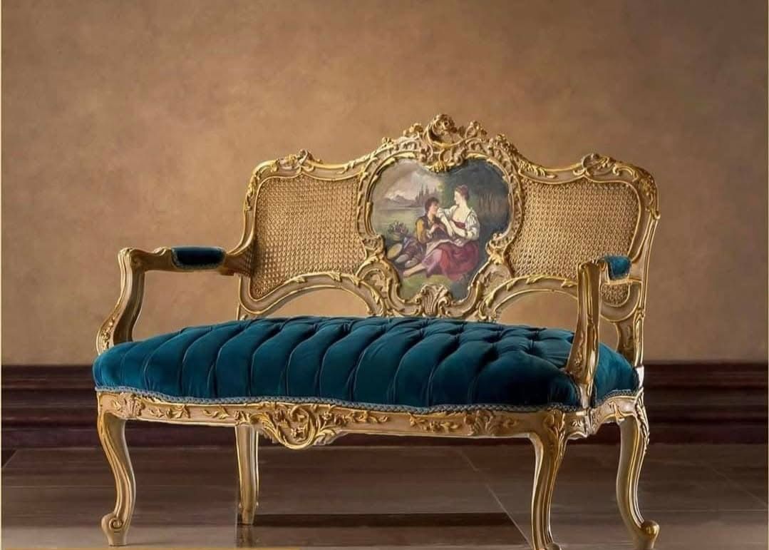 A blue and gold couch with a painting on the back.