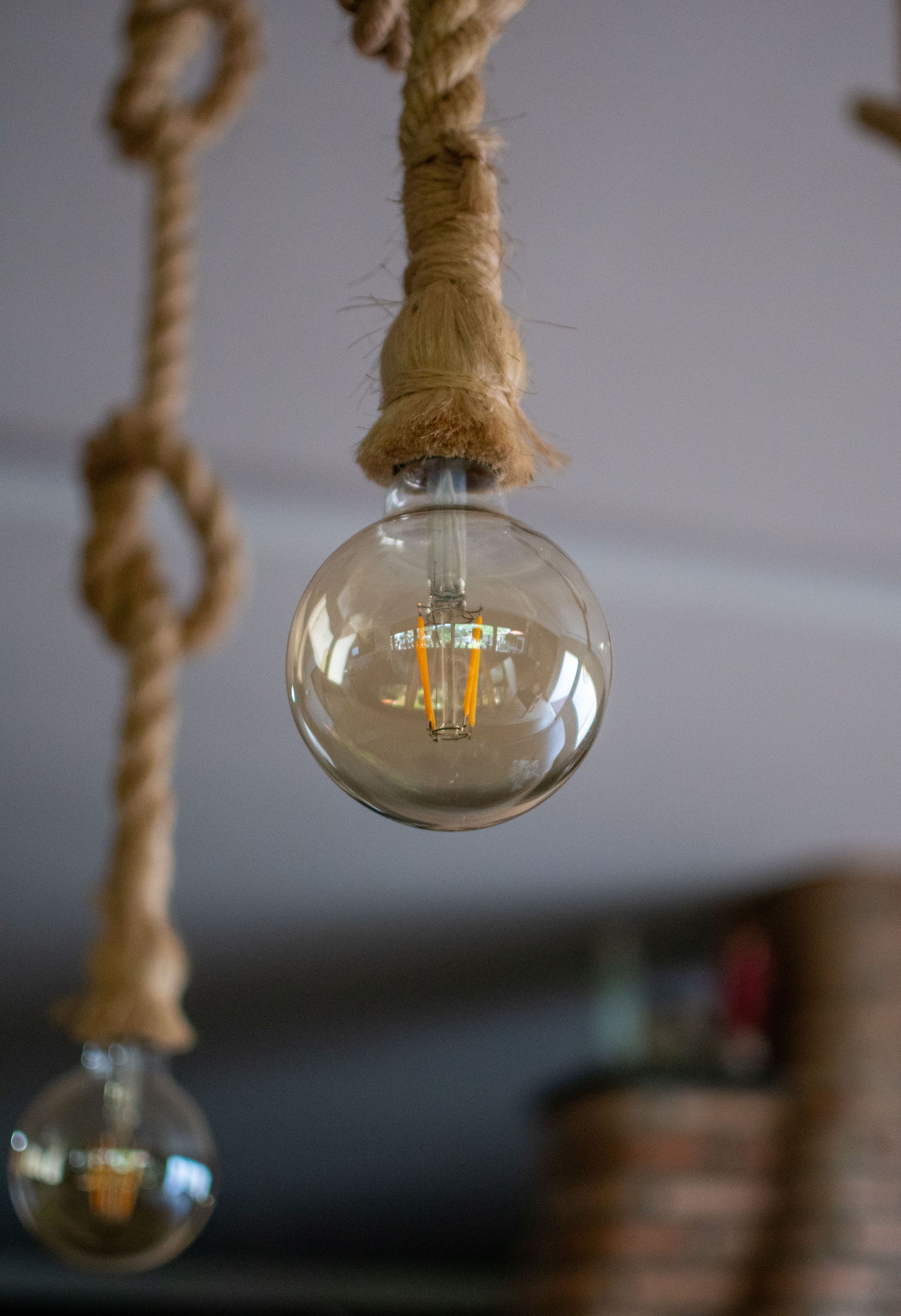 Lampadine a vista in stile Edison con cavi in ​​corda in un interno dalla luce soffusa.