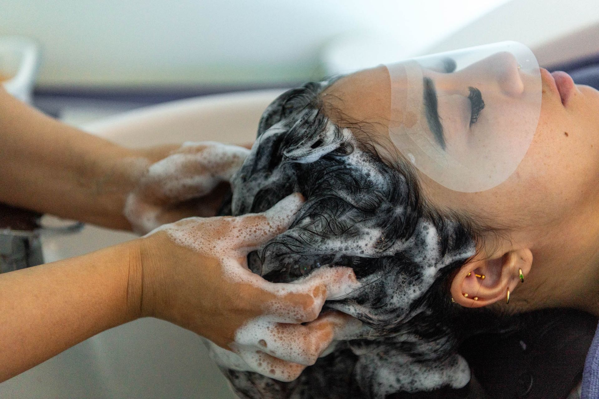 A woman is getting her hair cut by a hairdresser.