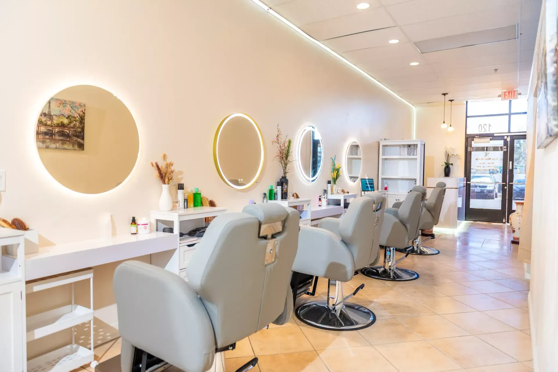 A row of chairs in a hair salon with mirrors.