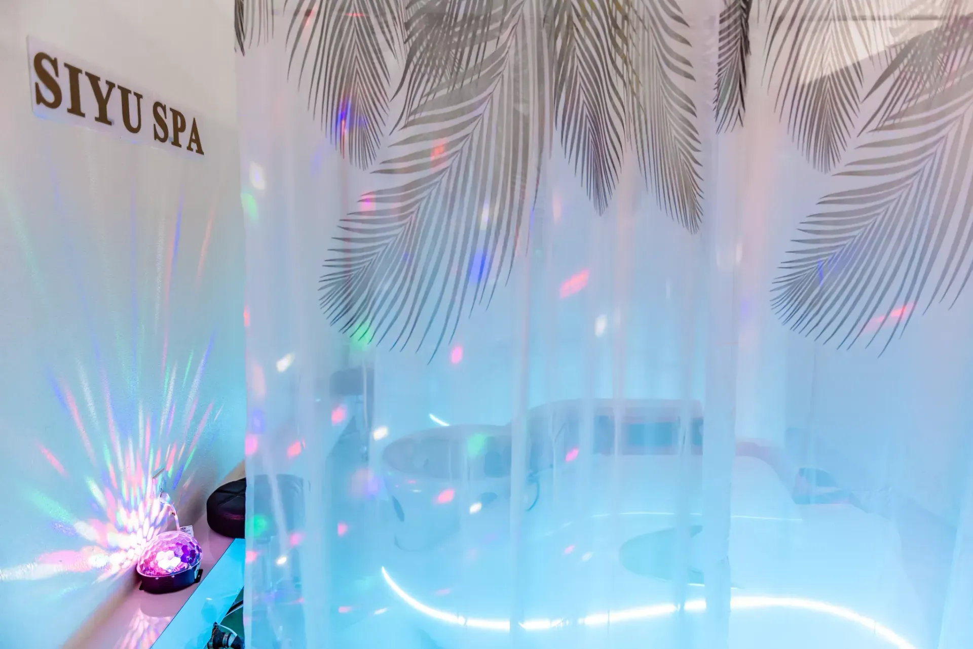 A bathroom with a shower curtain and a lamp.