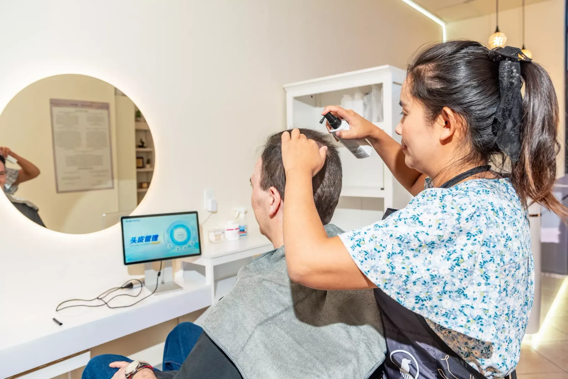 A woman is cutting a man 's hair in a salon.