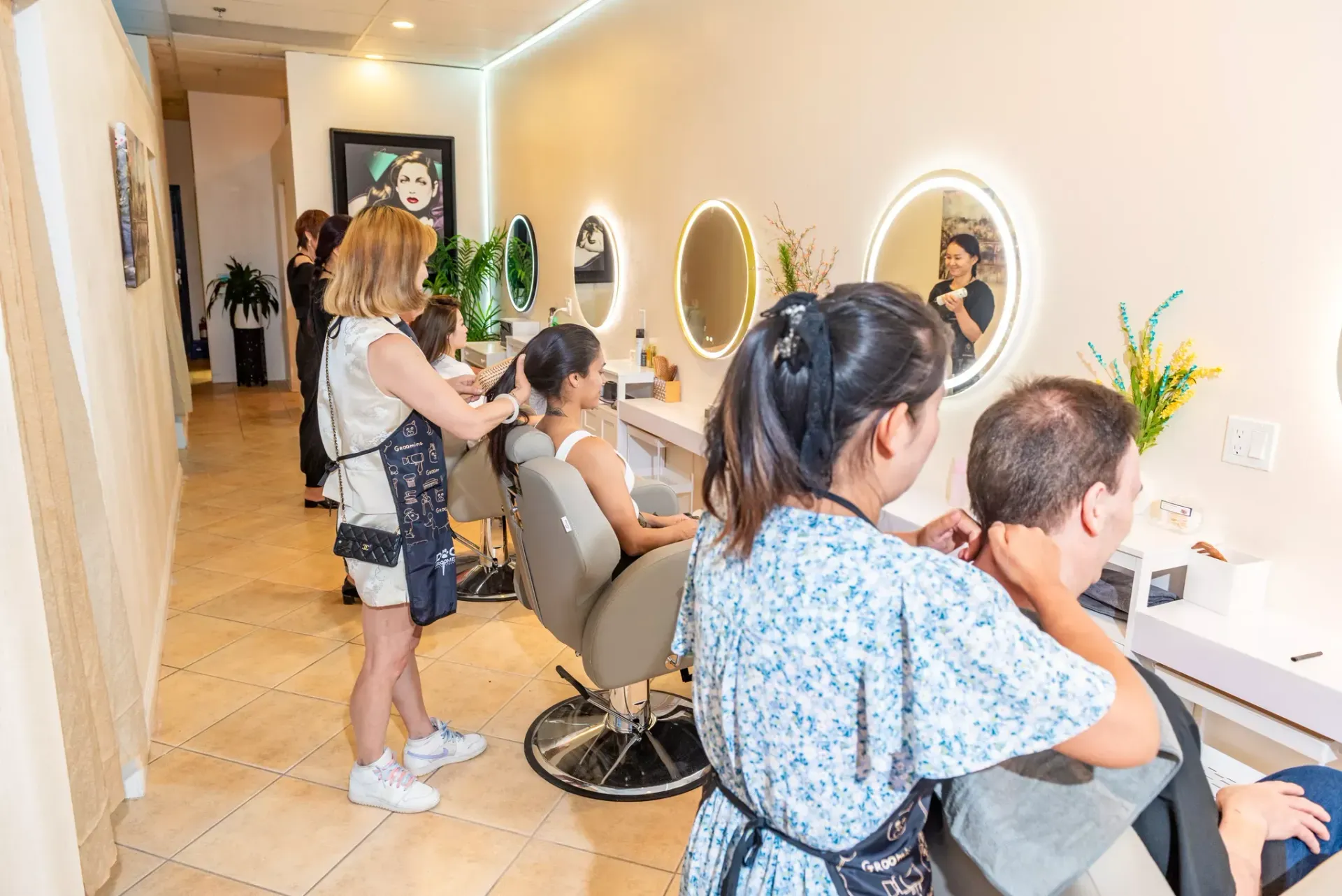 A woman is getting her hair cut by a hairdresser in a salon.