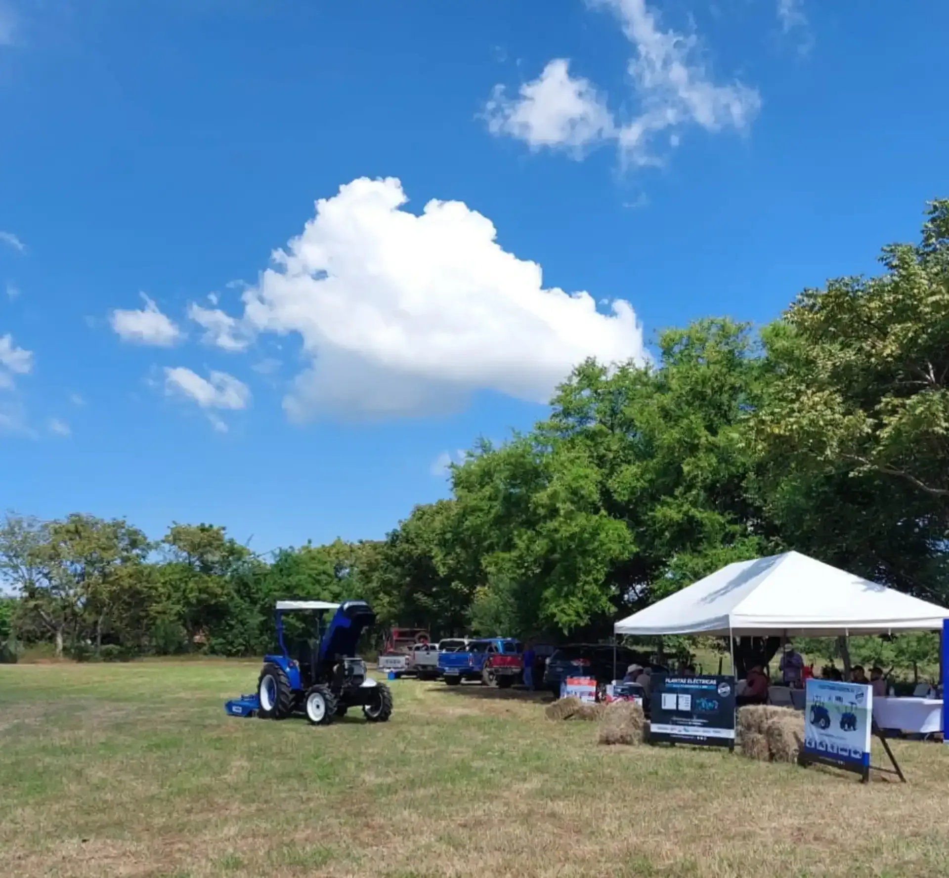 Un tractor azul está estacionado en un campo de hierba