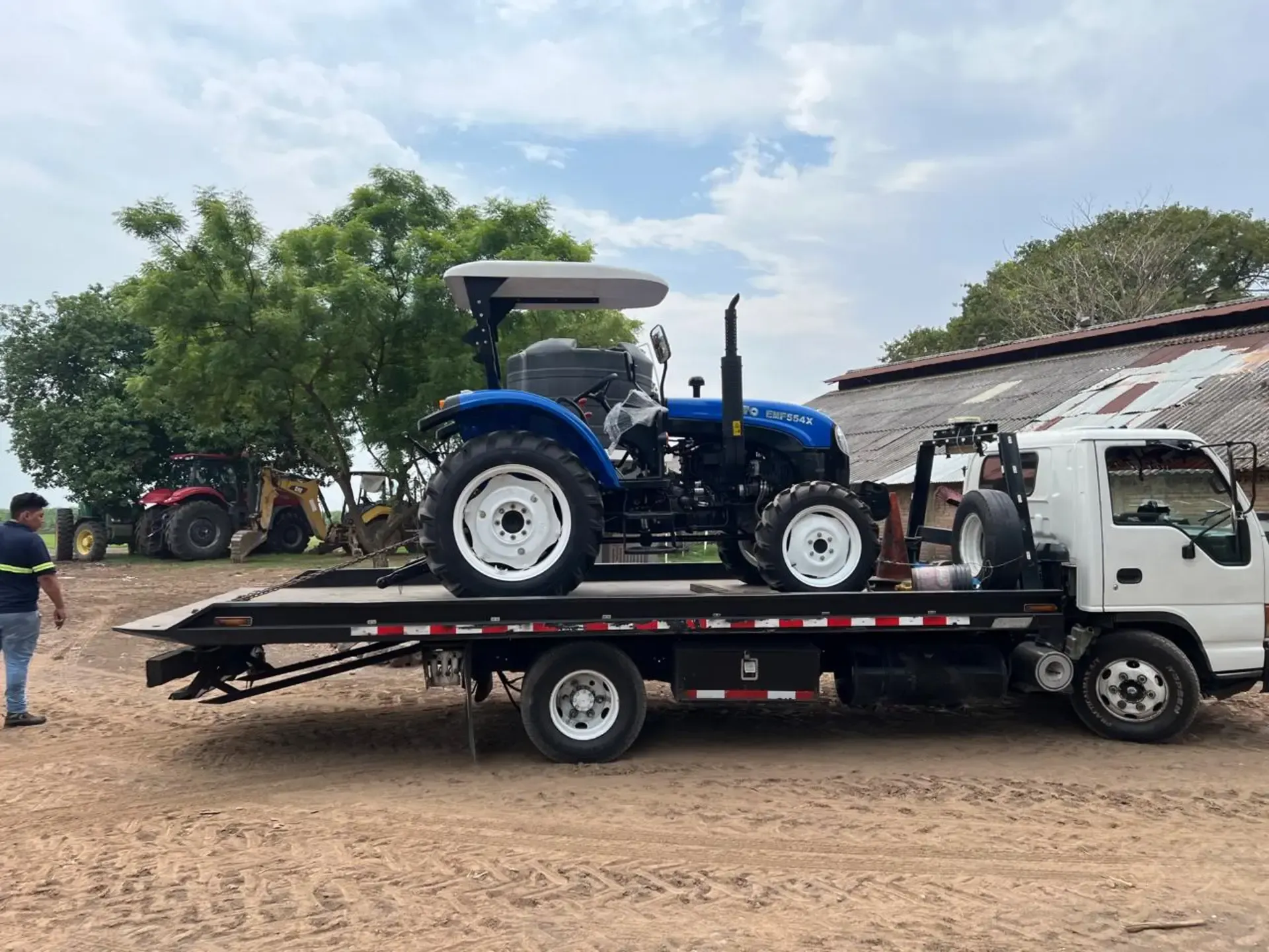 Un tractor está siendo remolcado por una grúa.