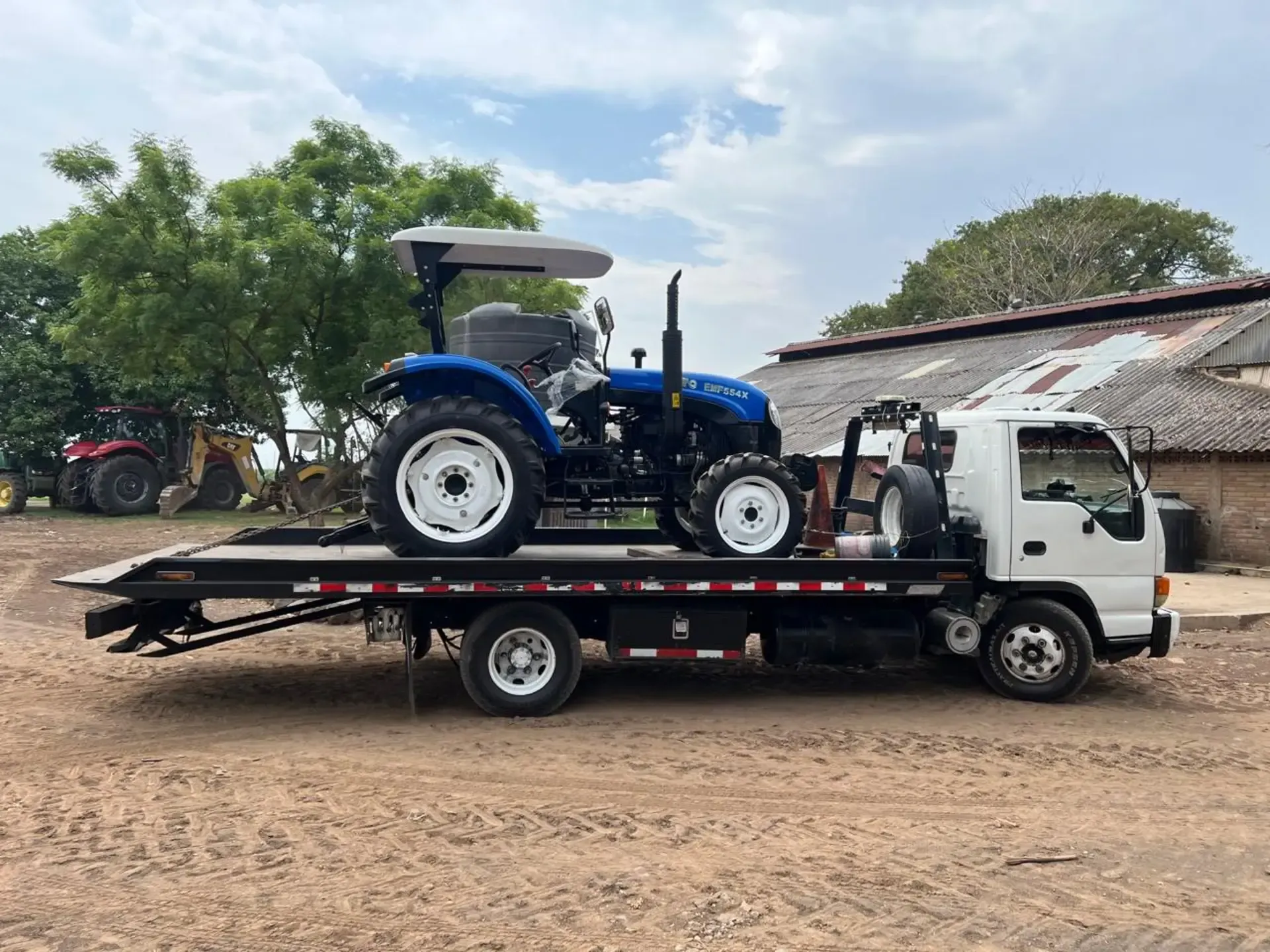 Un tractor está siendo remolcado por una grúa.