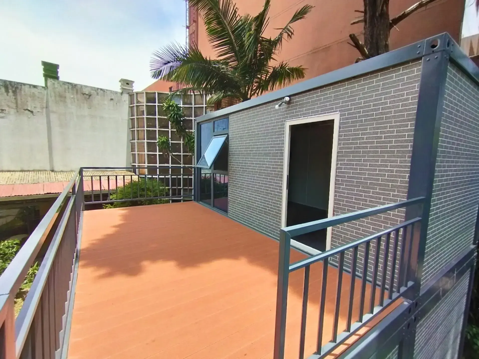 Un balcón con un edificio de ladrillo al fondo