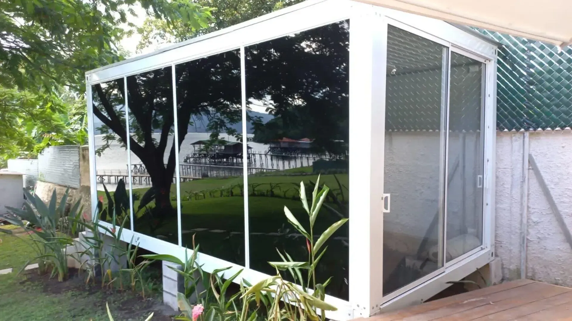 Un porche cubierto con un árbol al fondo