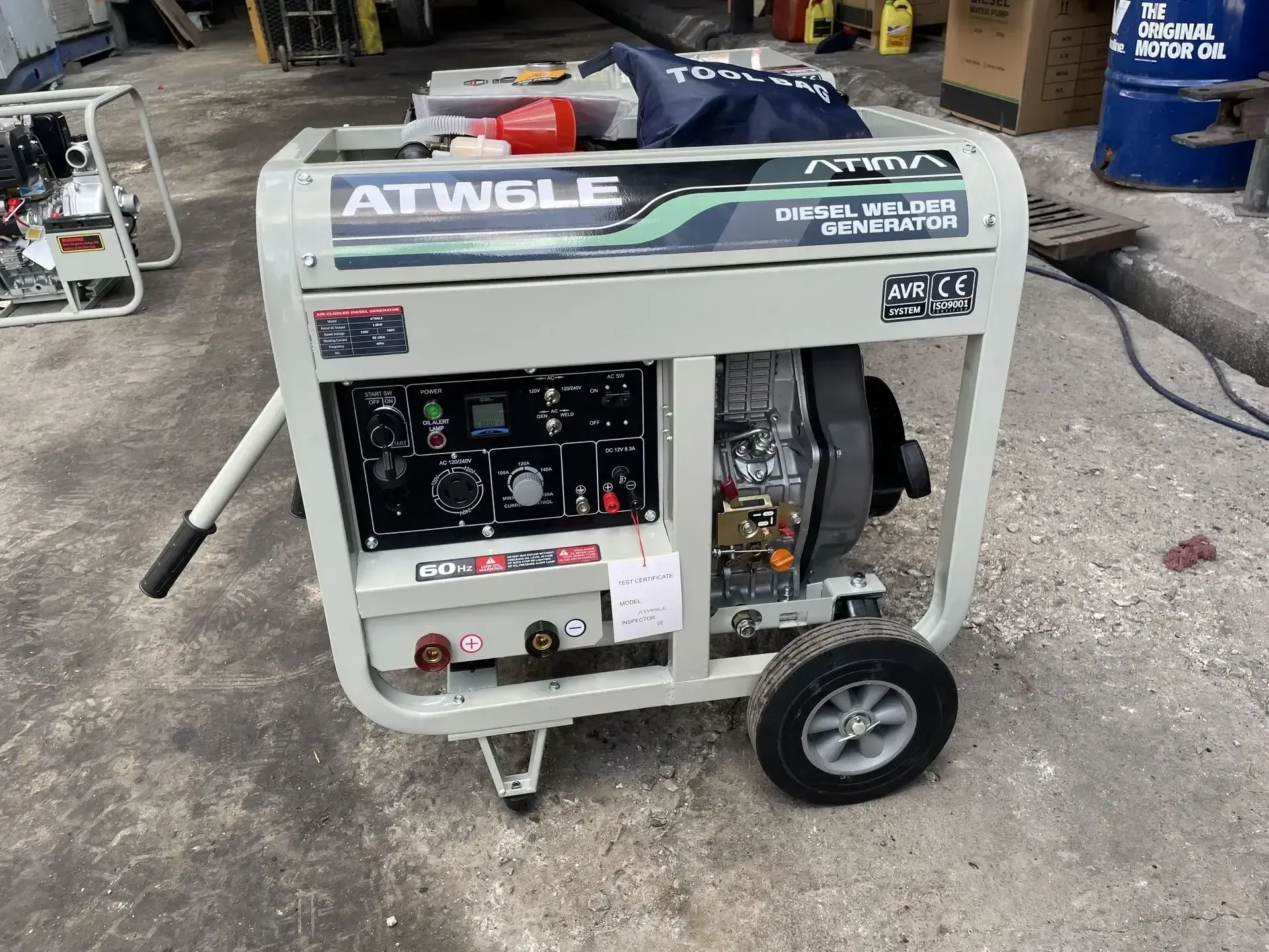 Un generador con ruedas está sentado en el suelo de un garaje.