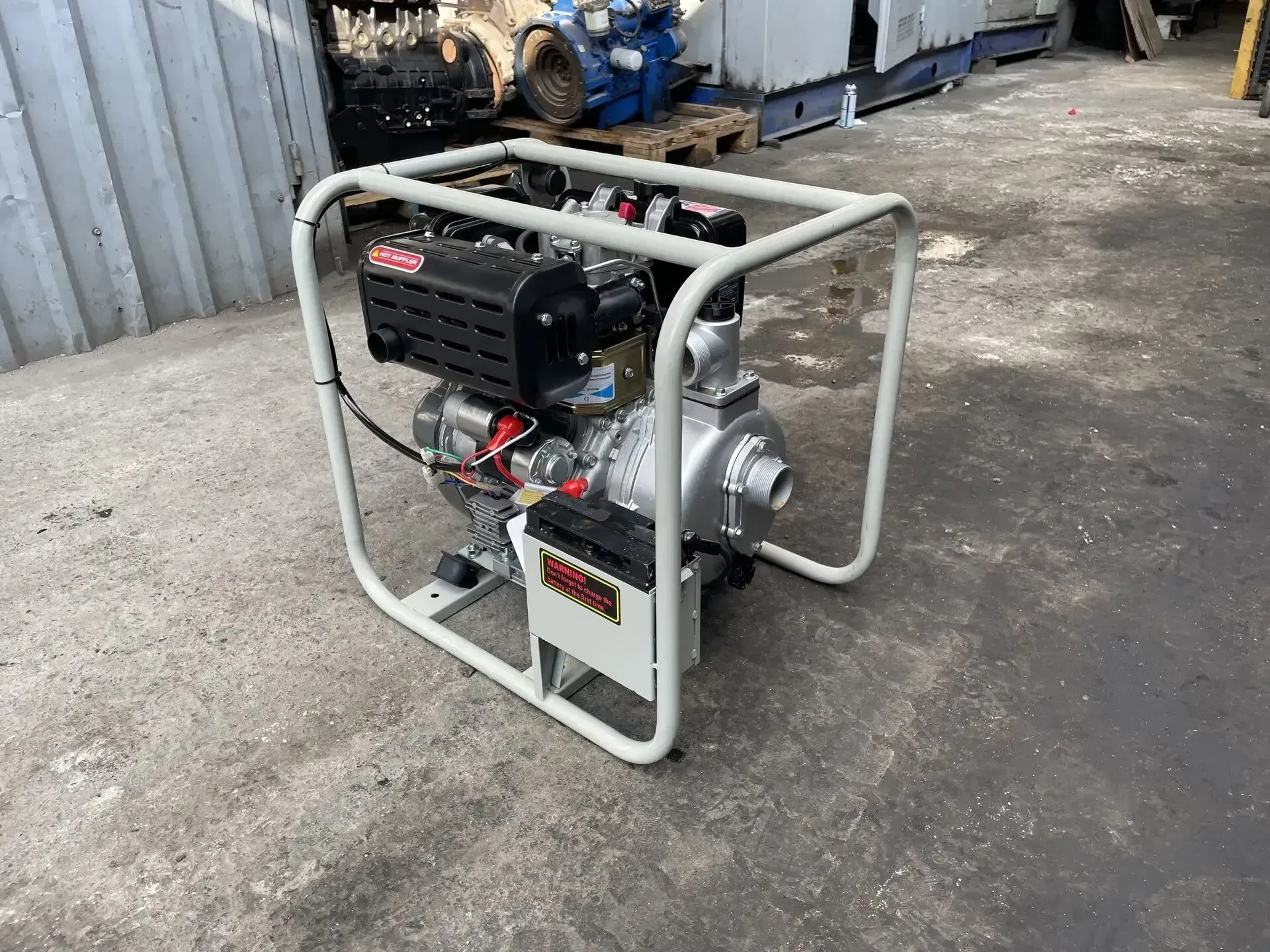 Una pequeña bomba de agua está colocada en el suelo de un garaje.