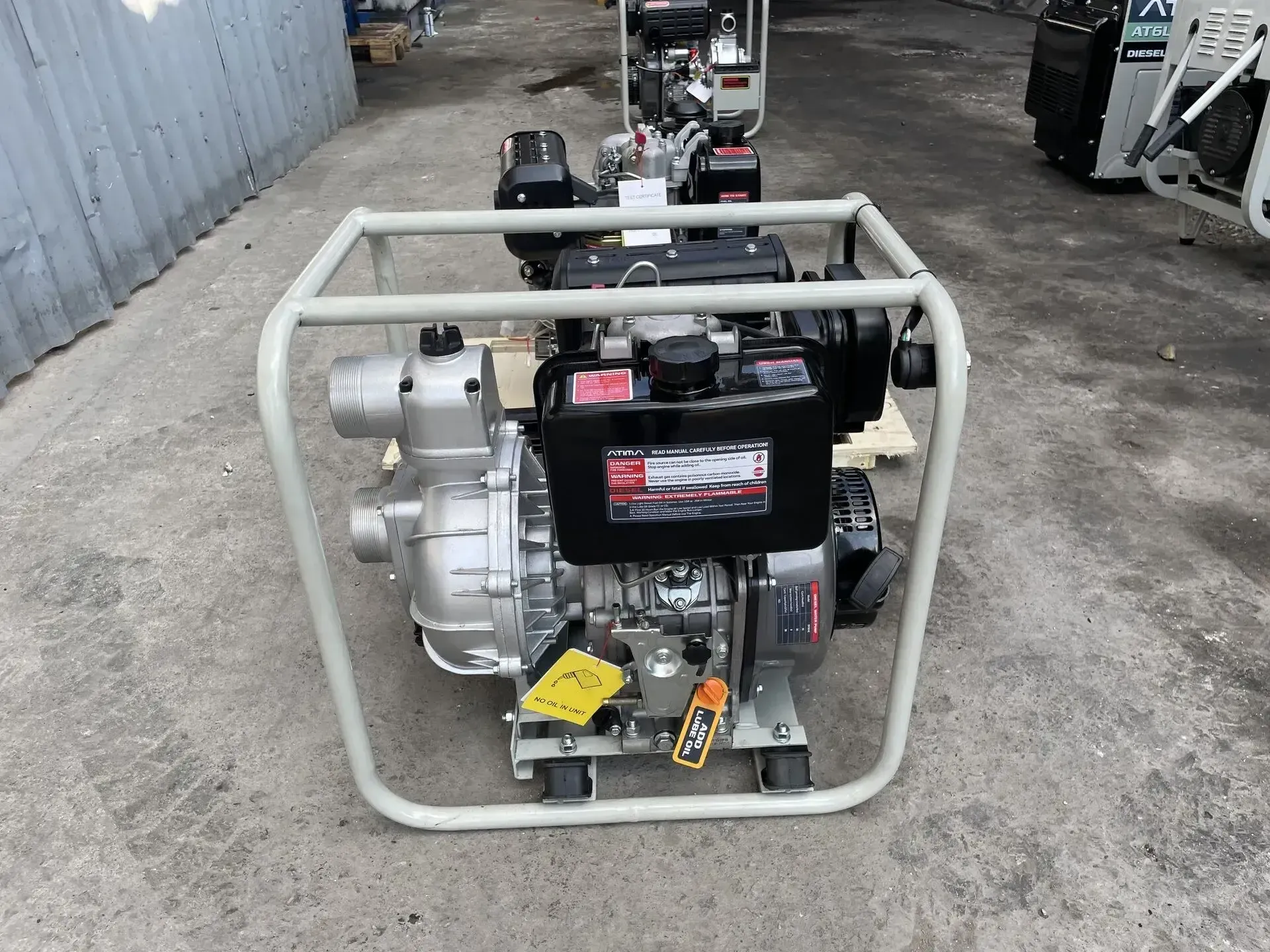 Una bomba de agua diesel está sentada en el suelo en una jaula.