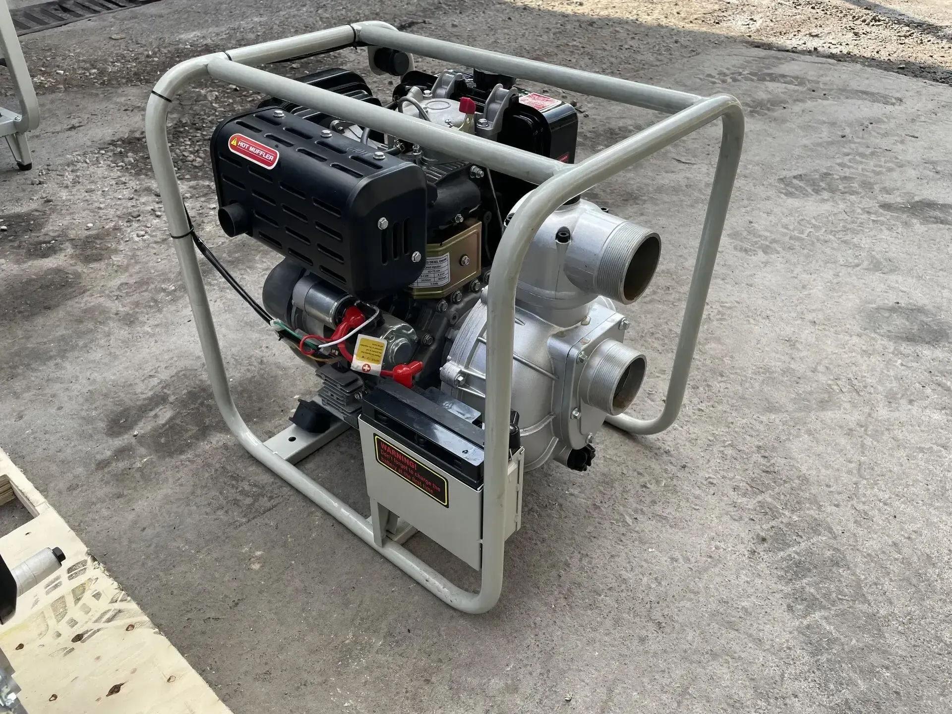 Una bomba de agua está colocada en el suelo sobre una estructura de metal.