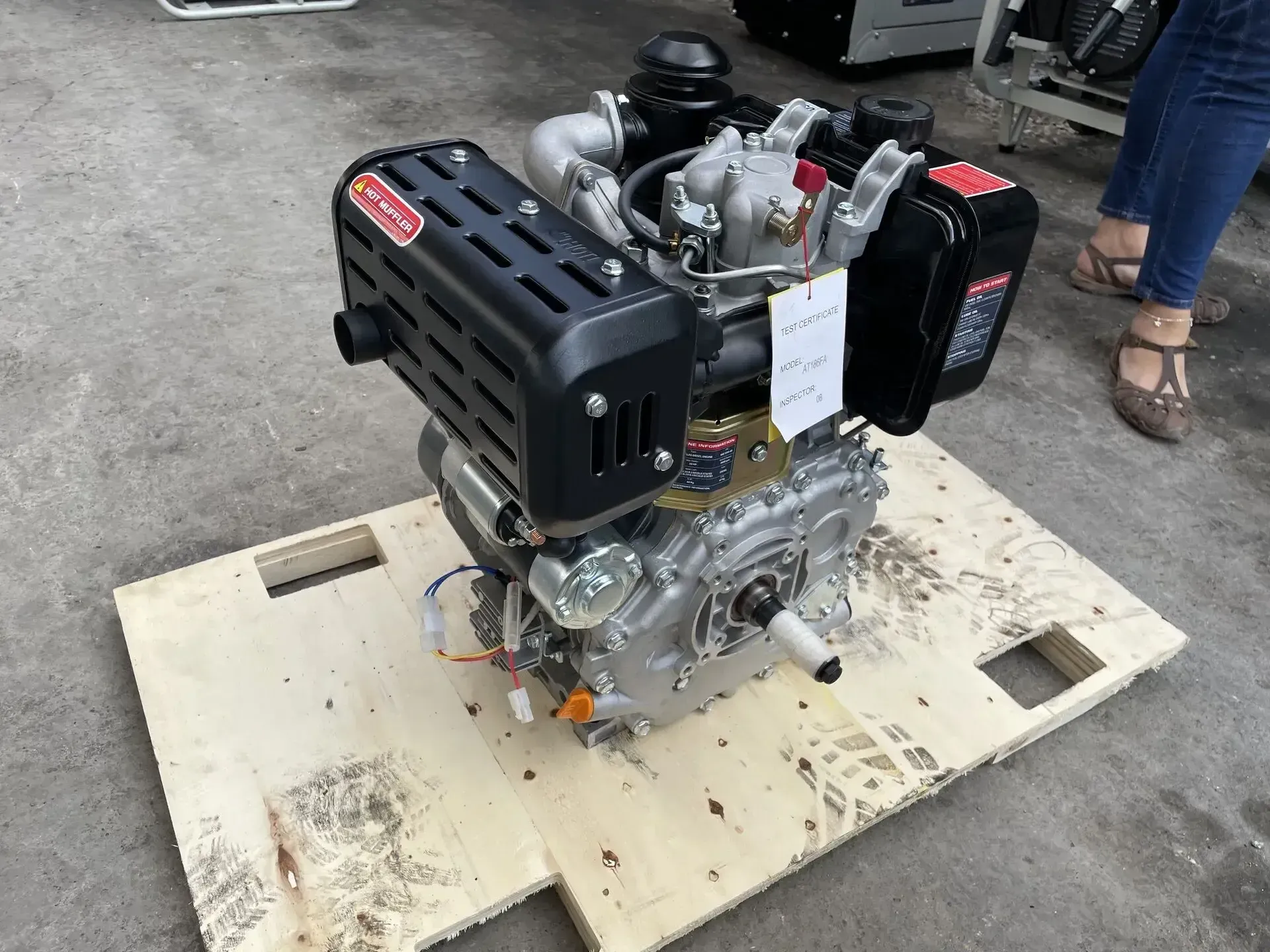 Un pequeño motor está colocado encima de una plataforma de madera.