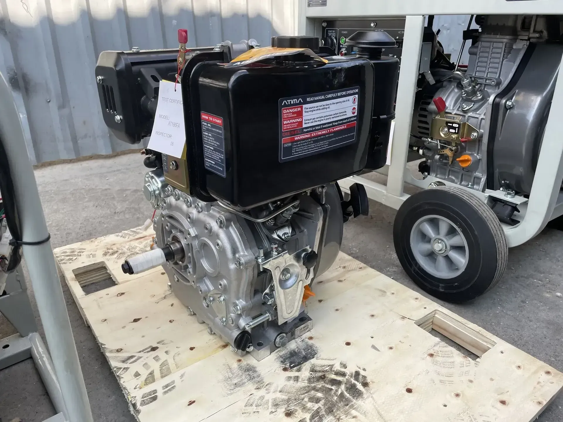 Un motor diésel está colocado encima de una plataforma de madera.