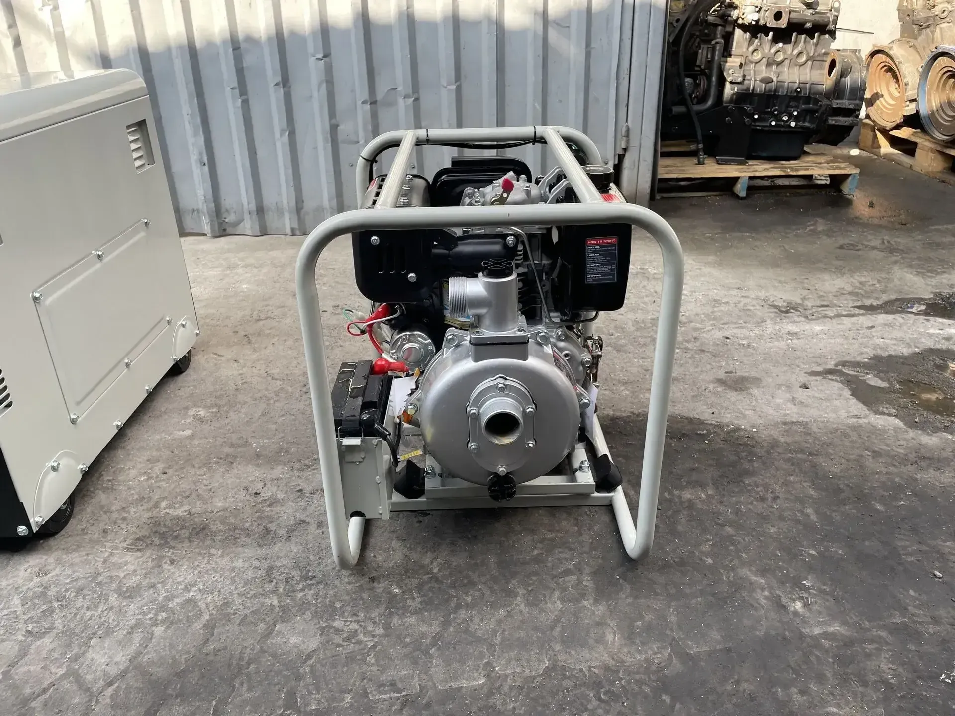 Una bomba de agua diésel está colocada en el suelo junto a un generador.