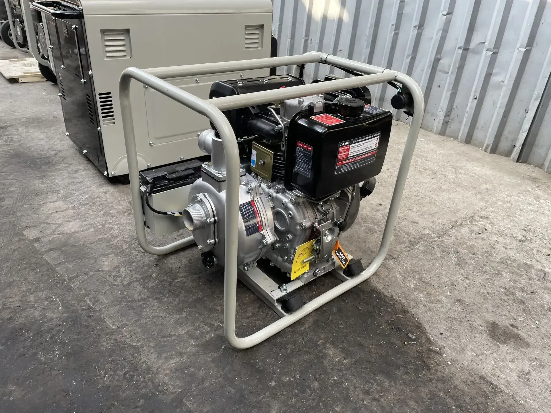 Una bomba de agua diésel está colocada en el suelo junto a un generador.